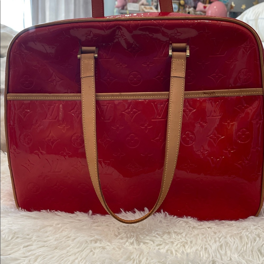 Authentic and vintage Louis Vuitton Sutton bag in red monogram vernis.
